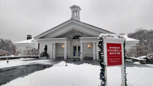The Norman Rockwell Museum, a white building with a snow-covered landscape, showcasing American illustration art.