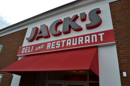 Sign for Jack's Deli and Restaurant, featuring bold red letters and a red awning.