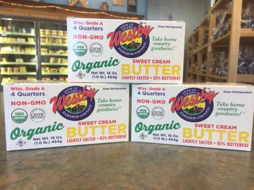 Three boxes of Westby organic sweet cream butter, labeled as non-GMO and lightly salted, displayed on a shelf.