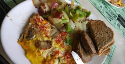 A plate of breakfast featuring an omelet, diced potatoes with peppers, and slices of toast.