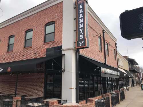 Exterior of Granny's restaurant, featuring a brick facade, large windows, and outdoor seating under black awnings.