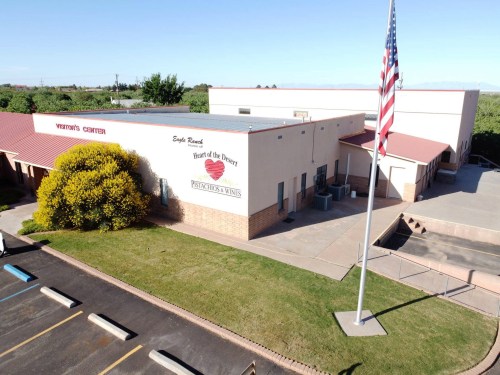 Aerial view of a building labeled "Heart of the Desert" with a flagpole and parking lot in front.