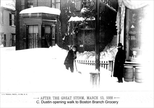 A historic black-and-white photo of a man shoveling snow outside a grocery store after a snowstorm in 1888.