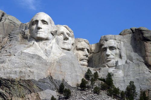 Mount Rushmore featuring the carved faces of four U.S. presidents: Washington, Jefferson, Roosevelt, and Lincoln.