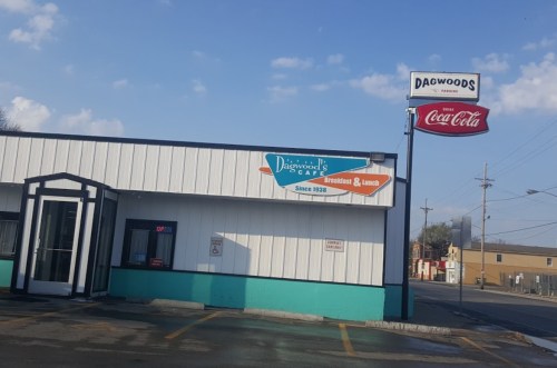 Exterior of Dagwood's Cafe, featuring a sign with "Breakfast & Lunch" and a Coca-Cola sign, under a blue sky.