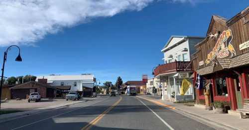 A quiet street in a small town, featuring shops, buildings, and clear blue skies.