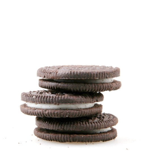 A stack of five chocolate sandwich cookies with cream filling, against a plain white background.