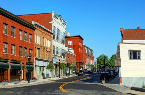 A sunny street view of a historic downtown area with brick buildings and clear blue skies.