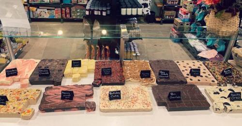 A display of various chocolate and candy bars in a shop, labeled with flavors like vanilla, strawberry, and more.