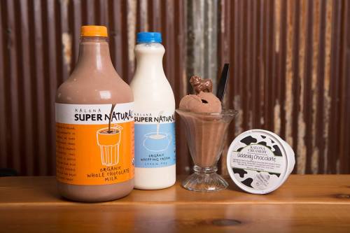Three bottles of milk and a dessert: one orange, one blue, and a chocolate ice cream in a glass with a scoop on top.