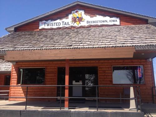 Exterior of the Twisted Tail restaurant in Beebeetown, Iowa, featuring a wooden facade and a sign above the entrance.