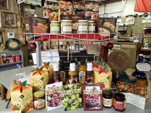 Display of various food products, including sauces, mixes, and beverages, arranged on shelves and tables.