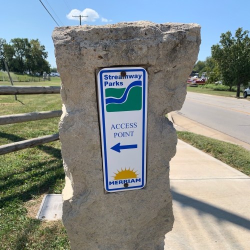 Sign on a stone pillar indicating the access point to Streamway Parks, with an arrow pointing left.