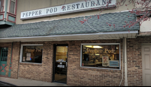 Exterior of Pepper Pod Restaurant, featuring a brick facade and large windows with the restaurant's name above.