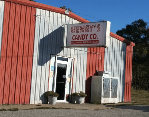 Exterior of Henry's Candy Co. building with a red and white striped facade and a sign above the entrance.