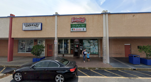 A storefront with a sign for "Valentino's" and a family walking outside, parked car in the foreground.