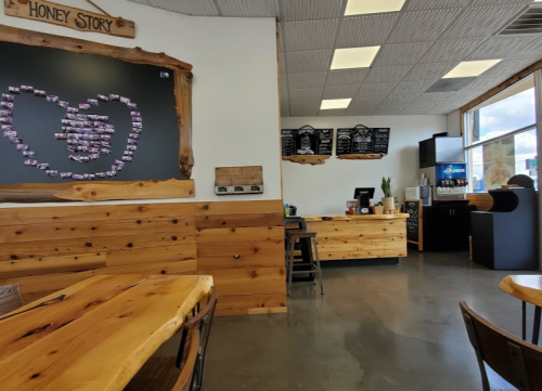 Cozy café interior with wooden decor, a chalkboard heart display, and a counter with menus and drinks.