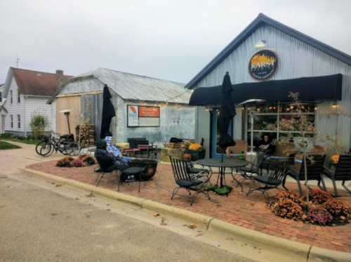 A cozy café with outdoor seating, surrounded by autumn decorations and bicycles parked nearby.