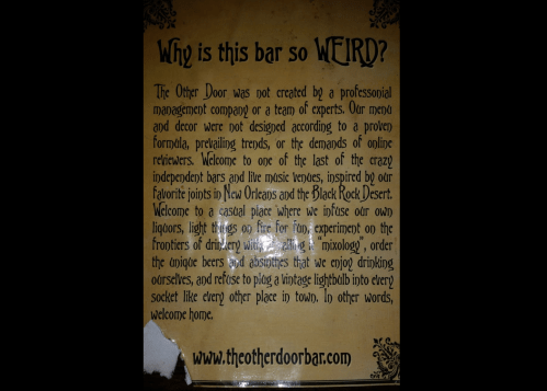 Sign explaining the unique concept of The Other Door bar, highlighting its independent spirit and casual vibe.