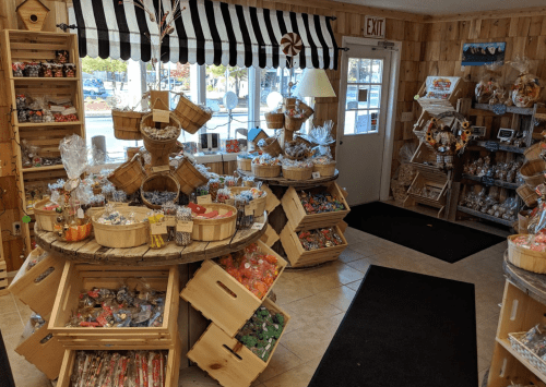 A cozy candy shop with wooden shelves, baskets of colorful candies, and a welcoming entrance.
