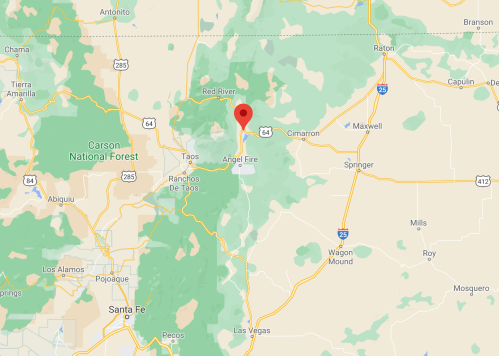 Map showing Angel Fire, New Mexico, marked with a red pin, surrounded by green areas and nearby towns.