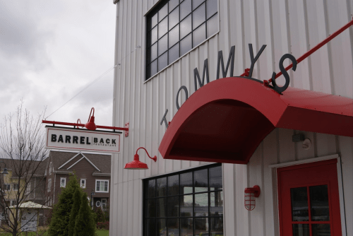 Exterior of a building with a sign reading "BARRELBACK" and an awning above the entrance, under a cloudy sky.
