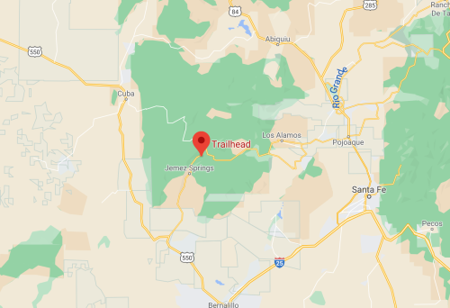 Map showing the location of a trailhead near Jemez Springs, New Mexico, surrounded by green areas and roads.