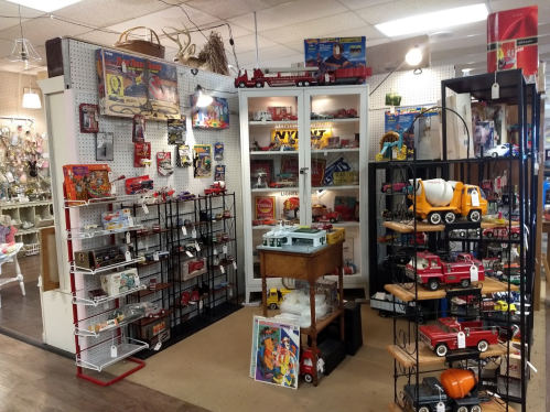 A vintage toy store display featuring shelves of toys, collectibles, and a wooden table with various items.