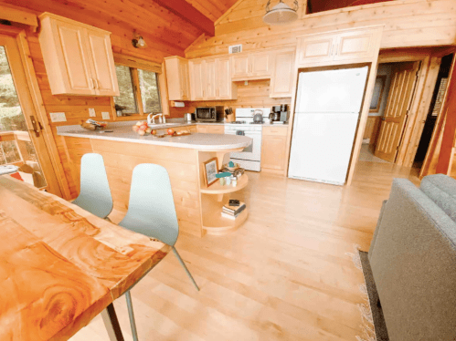 Cozy wooden kitchen with a dining table, modern appliances, and a bright, inviting atmosphere.