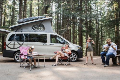A family enjoys a camping trip near a van, with a child drawing, a woman reading, and two boys playing music.