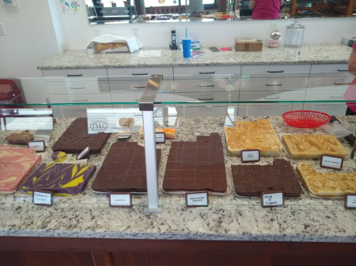 A display of various fudge flavors on a granite countertop, with labels for each type.