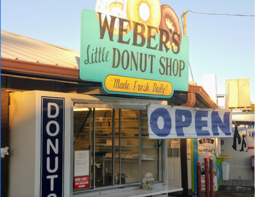 Sign for Weber's Little Donut Shop, featuring "Open" banner and a display window for fresh donuts.