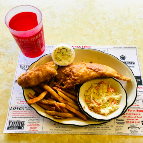 A plate of fried fish, coleslaw, and fries, accompanied by a drink in a red cup, on a printed menu background.