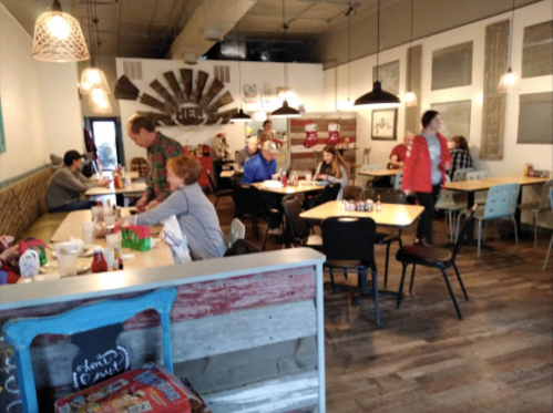 A cozy restaurant interior with diners at tables, colorful decor, and a warm atmosphere.