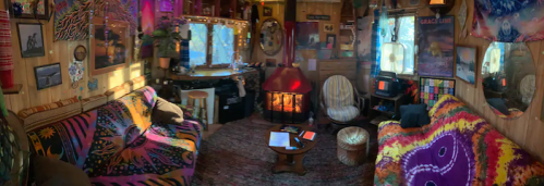 Cozy interior of a colorful cabin with a fireplace, eclectic decor, and warm lighting.