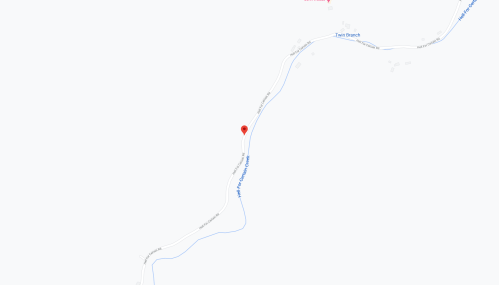 Map showing a location marked with a red pin along a winding road near a creek.