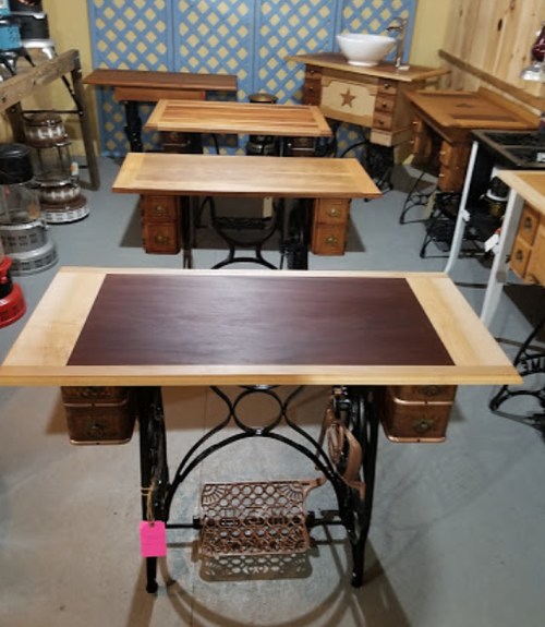 A collection of vintage-style tables with wooden tops and decorative metal bases, arranged in a rustic setting.