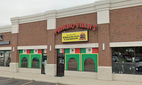 Exterior of Pancho Villa's restaurant featuring colorful windows and a sign for authentic Mexican cuisine.