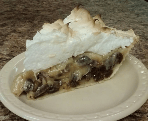 A slice of pie with a flaky crust, filled with bananas and topped with fluffy meringue.