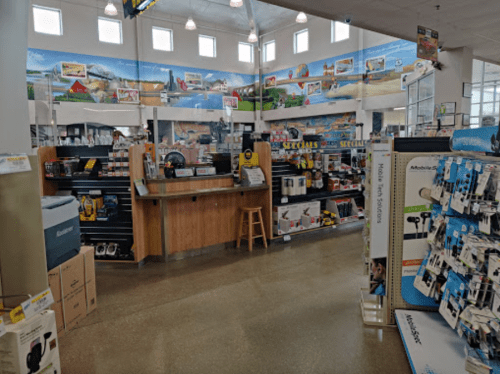 A retail store interior featuring a checkout counter, shelves of products, and colorful wall murals.