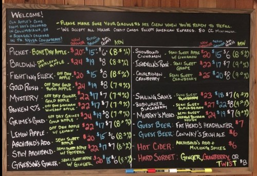 Chalkboard menu listing various beverages and prices, including ciders, beers, and hard sorbets.