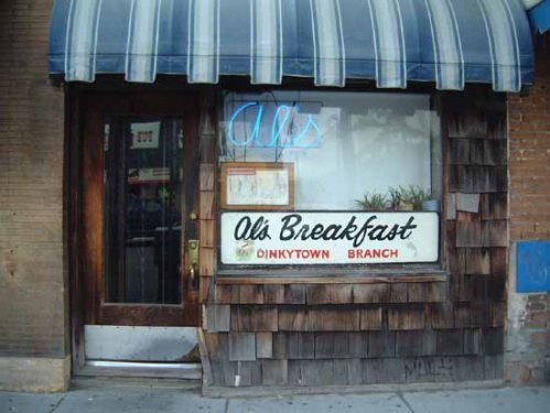 Exterior of Al's Breakfast, featuring a wooden facade, blue awning, and a sign reading "Al's Breakfast Dinkytown Branch."
