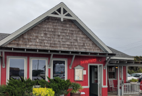 A red restaurant with a shingled roof, featuring a sign that reads "Skeeters" and surrounded by greenery.