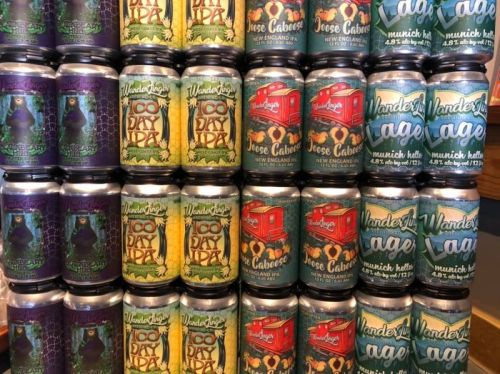A colorful display of various beer cans stacked neatly, featuring different designs and labels.