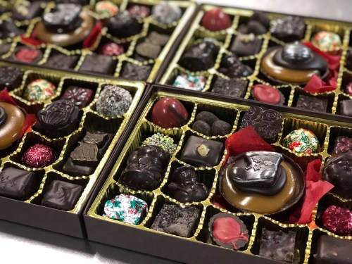 A variety of assorted chocolates in decorative boxes, featuring different shapes, colors, and textures.