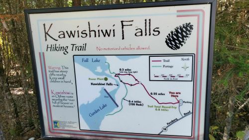 Sign for Kawishiwi Falls hiking trail, detailing distances, map, and warning about steep cliffs. No motorized vehicles allowed.