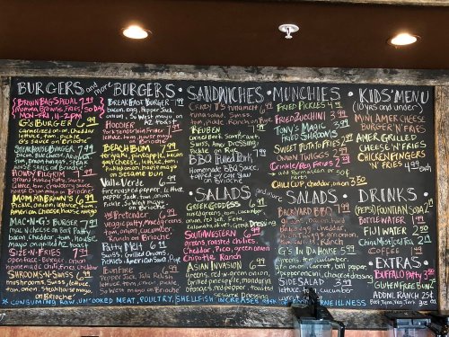 Chalkboard menu featuring burgers, sandwiches, salads, munchies, kids' menu, and drinks with prices listed.