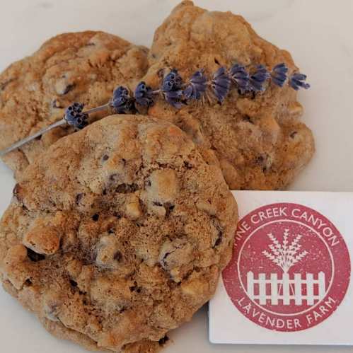 Three cookies with chocolate chips and a sprig of lavender, accompanied by a logo for Pine Creek Canyon Lavender Farm.