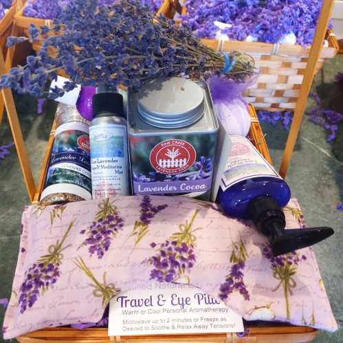 A basket filled with lavender products, including a cocoa tin, mist, and a soothing eye pillow.