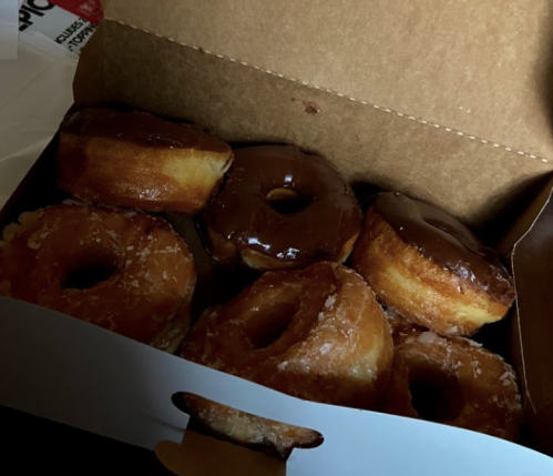 A box of assorted donuts, including glazed and chocolate-covered varieties.
